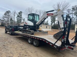 A Bobcat mini excavator and a tilt trailer purchased by Schmidt, with the help of the Oakmont team.